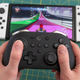 Photo of a GuliKit KingKong Pro 2 controller and a Nintendo Switch OLED